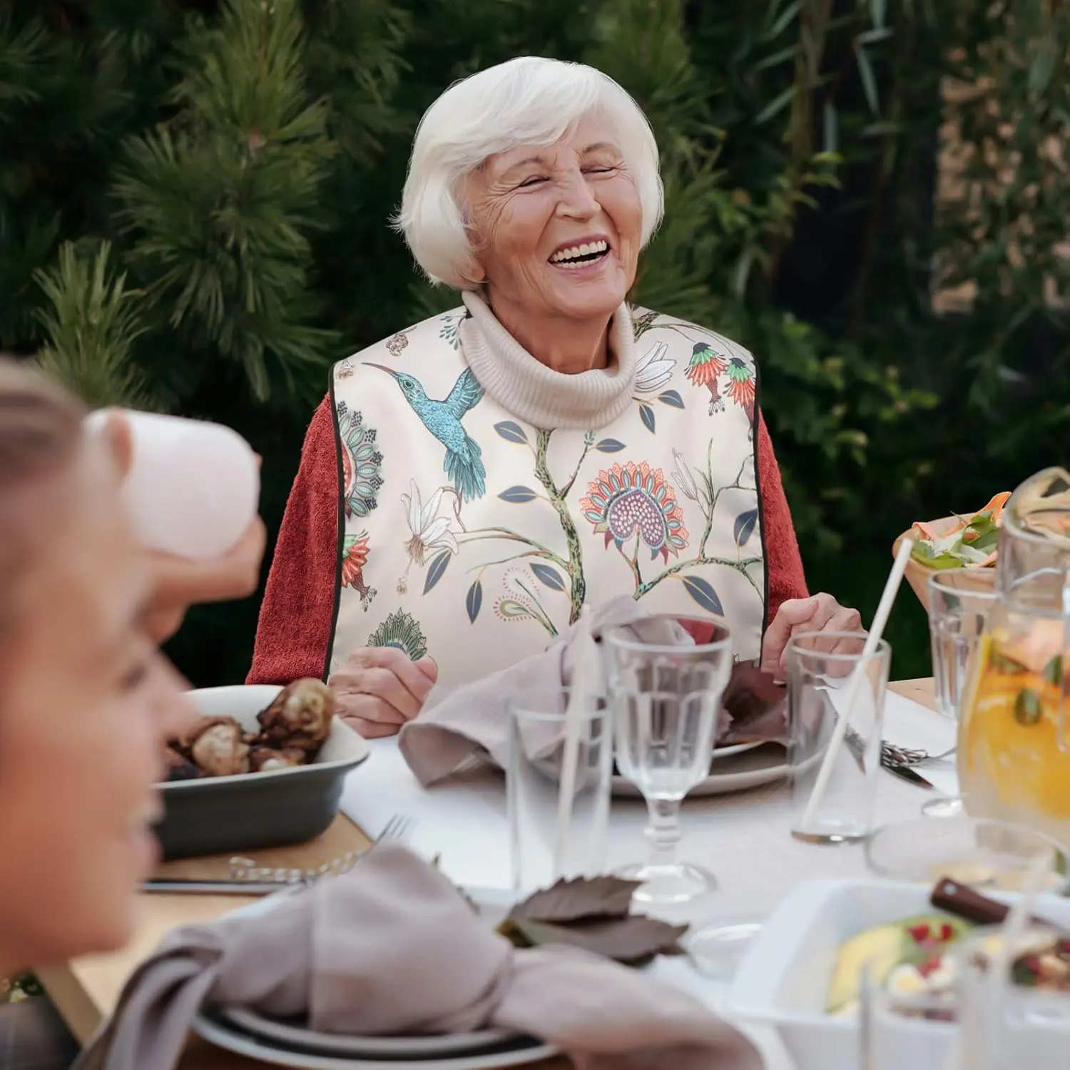 This waterproof adult bib dining apron provides clothing protection for seniors, elderly, and disabled patients during mealtimes and other messy activities.