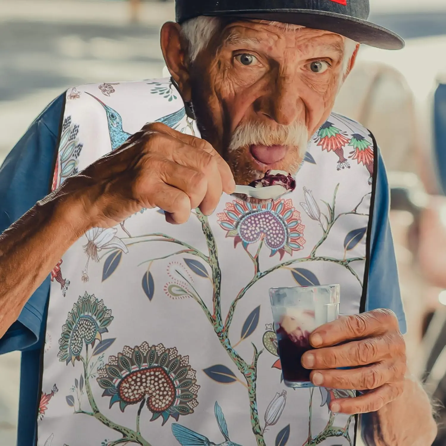 This waterproof adult bib dining apron provides clothing protection for seniors, elderly, and disabled patients during mealtimes and other messy activities.