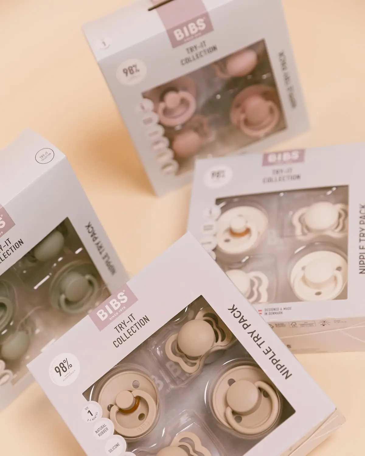This Bibs baby pacifier try-it box contains four BPA-free pacifiers in ivory, featuring natural rubber and silicone nipples designed for sensitive mouths and babies up to 6 months old.