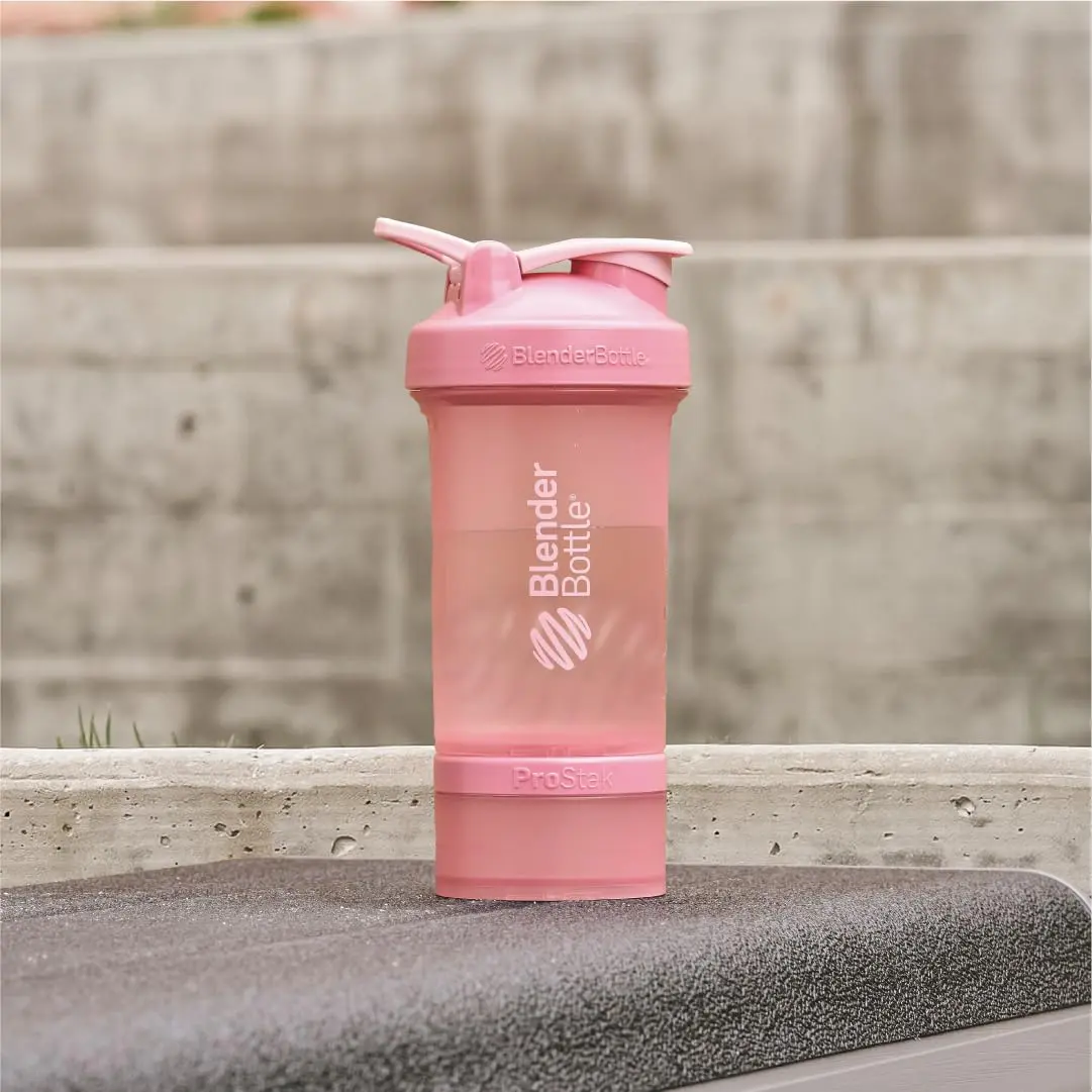 Rose pink BlenderBottle ProStak shaker bottle with pill organizer and powder storage for protein mixes.