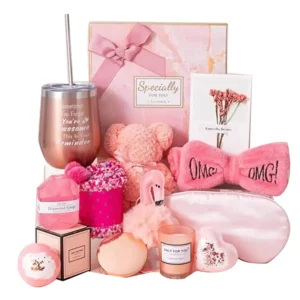 This pink gift basket for women includes a tumbler, scented candle, handmade soap, bath bomb, towel, eye mask, headband, socks, keychain, mirror, and a greeting card, perfect for birthdays or Mother's Day.