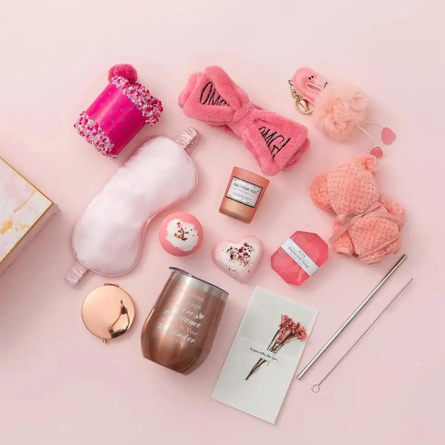 This pink gift basket for women includes a tumbler, scented candle, handmade soap, bath bomb, towel, eye mask, headband, socks, keychain, mirror, and a greeting card, perfect for birthdays or Mother's Day.