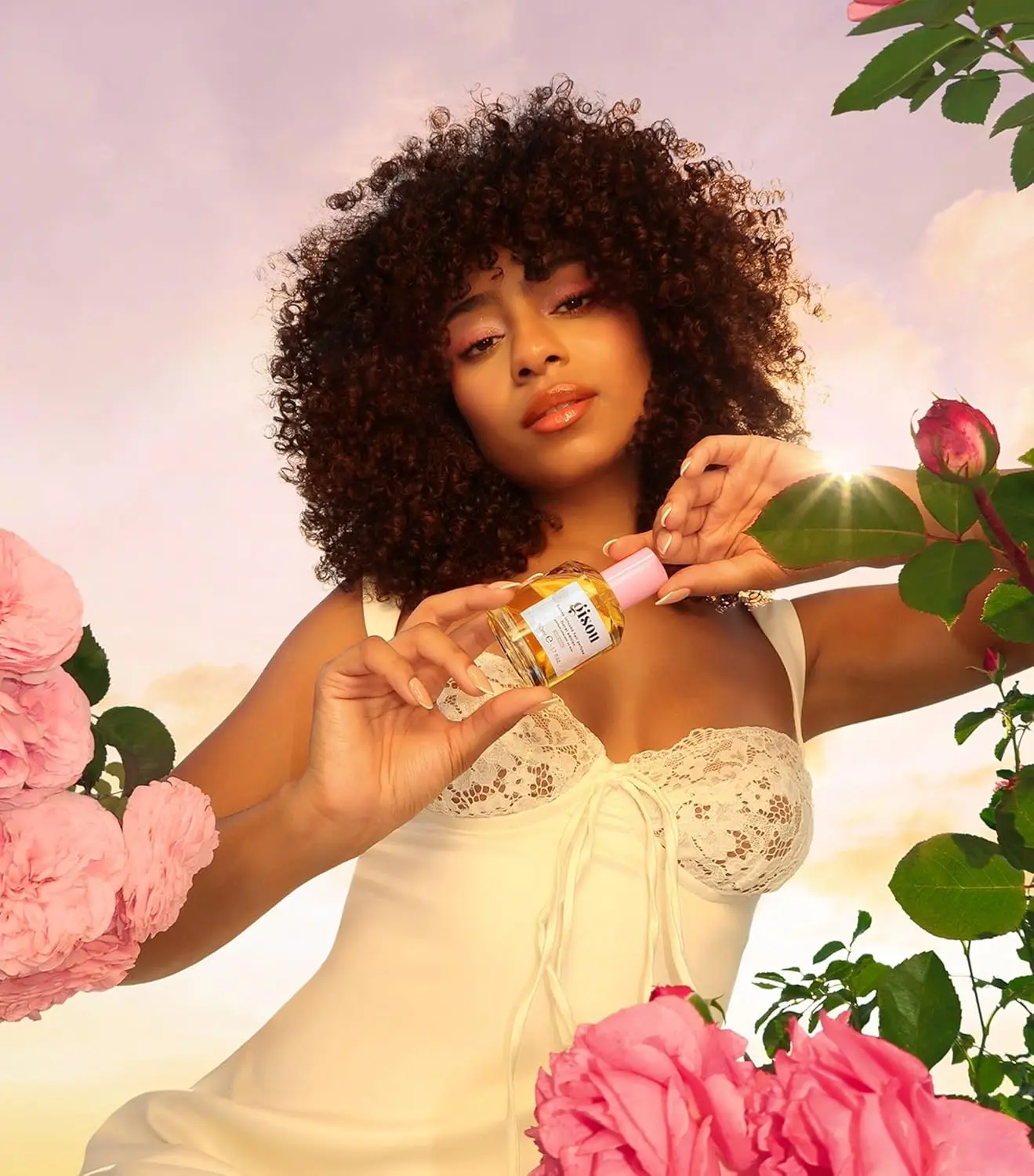 A bottle of GISOU Wild Rose Hair Perfume infused with honey, offering UV protection and a refreshing, garden-inspired fragrance.
