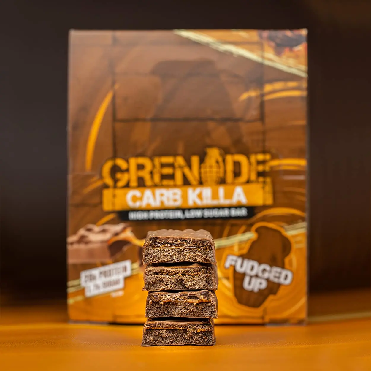A pack of Grenade Carb Killa Fudged Up protein bars, a low sugar snack with a soft fudge center, caramel layer, and milk chocolate coating, providing 20g of protein per bar.