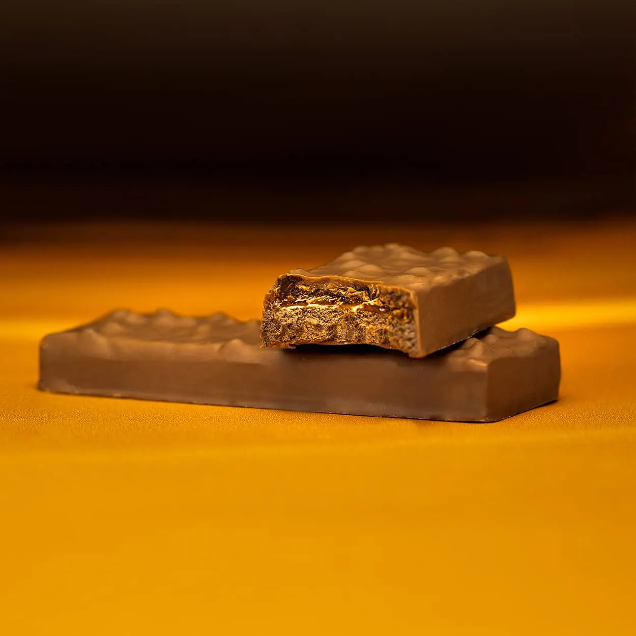 A pack of Grenade Carb Killa Fudged Up protein bars, a low sugar snack with a soft fudge center, caramel layer, and milk chocolate coating, providing 20g of protein per bar.