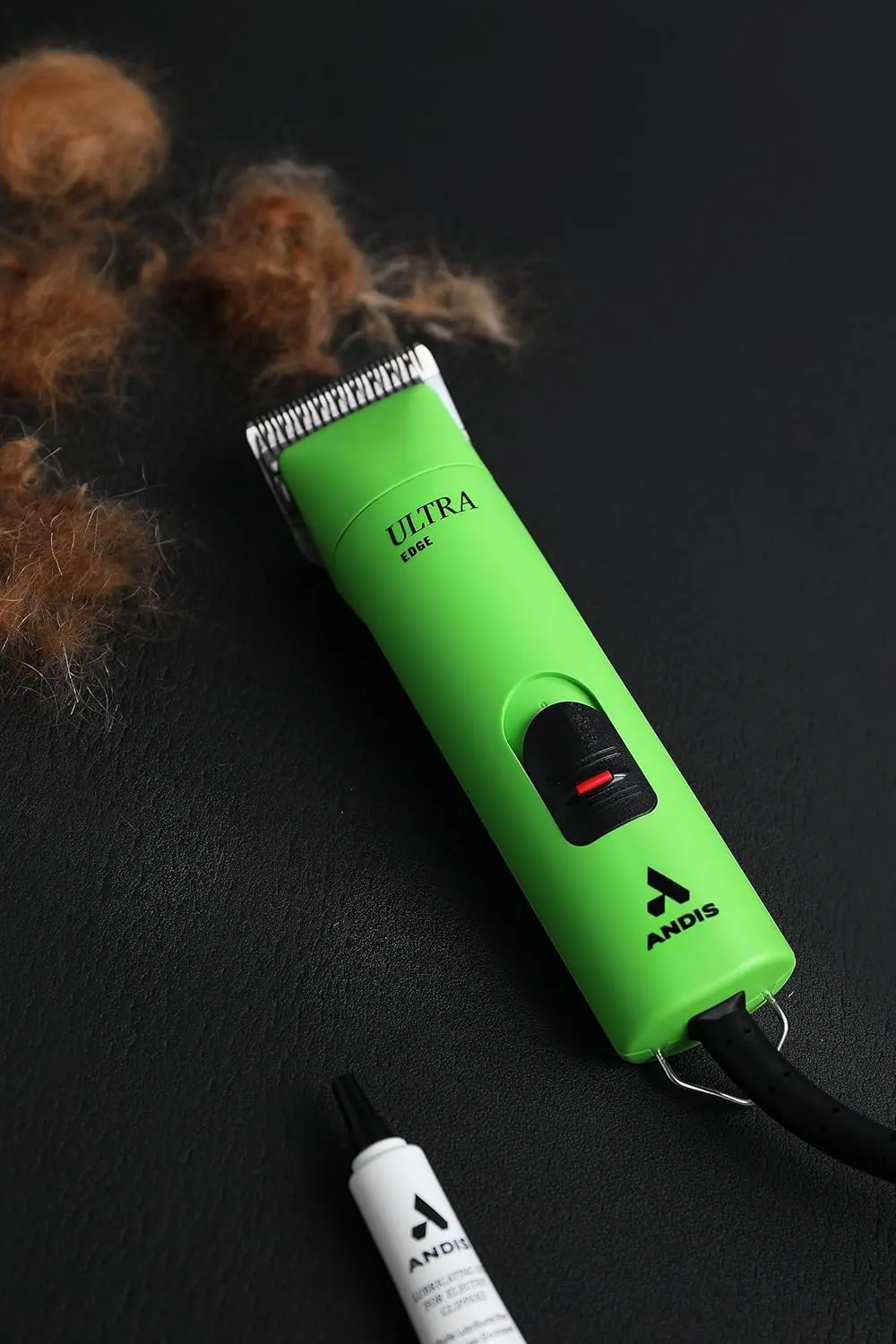 The Andis UltraEdge Super 2-Speed clipper in spring green quickly and quietly trims thick dog hair with its sharp, detachable blade.