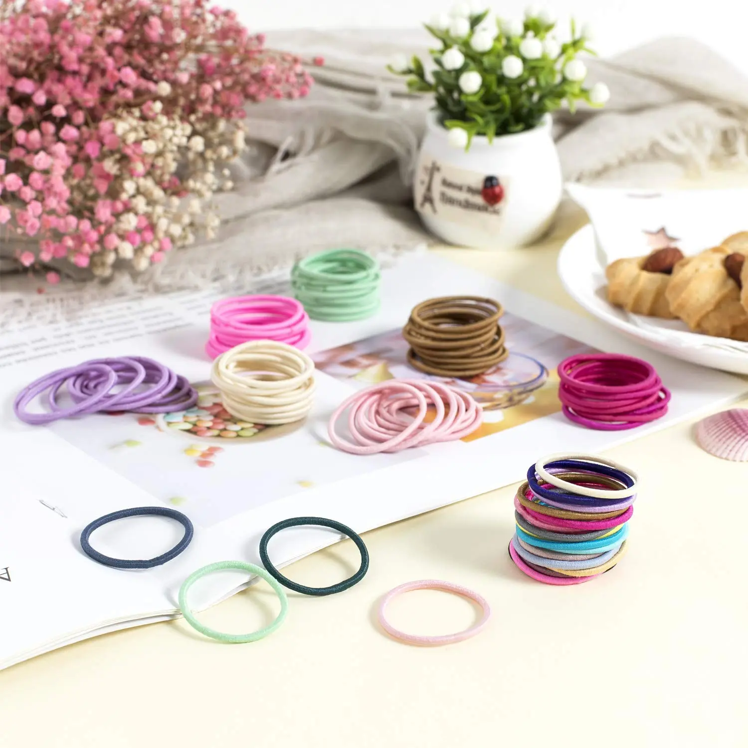A collection of 200 small, colorful hair ties in about 20 different colors, perfect for creating ponytails and hairstyles for babies, toddlers, and little girls.
