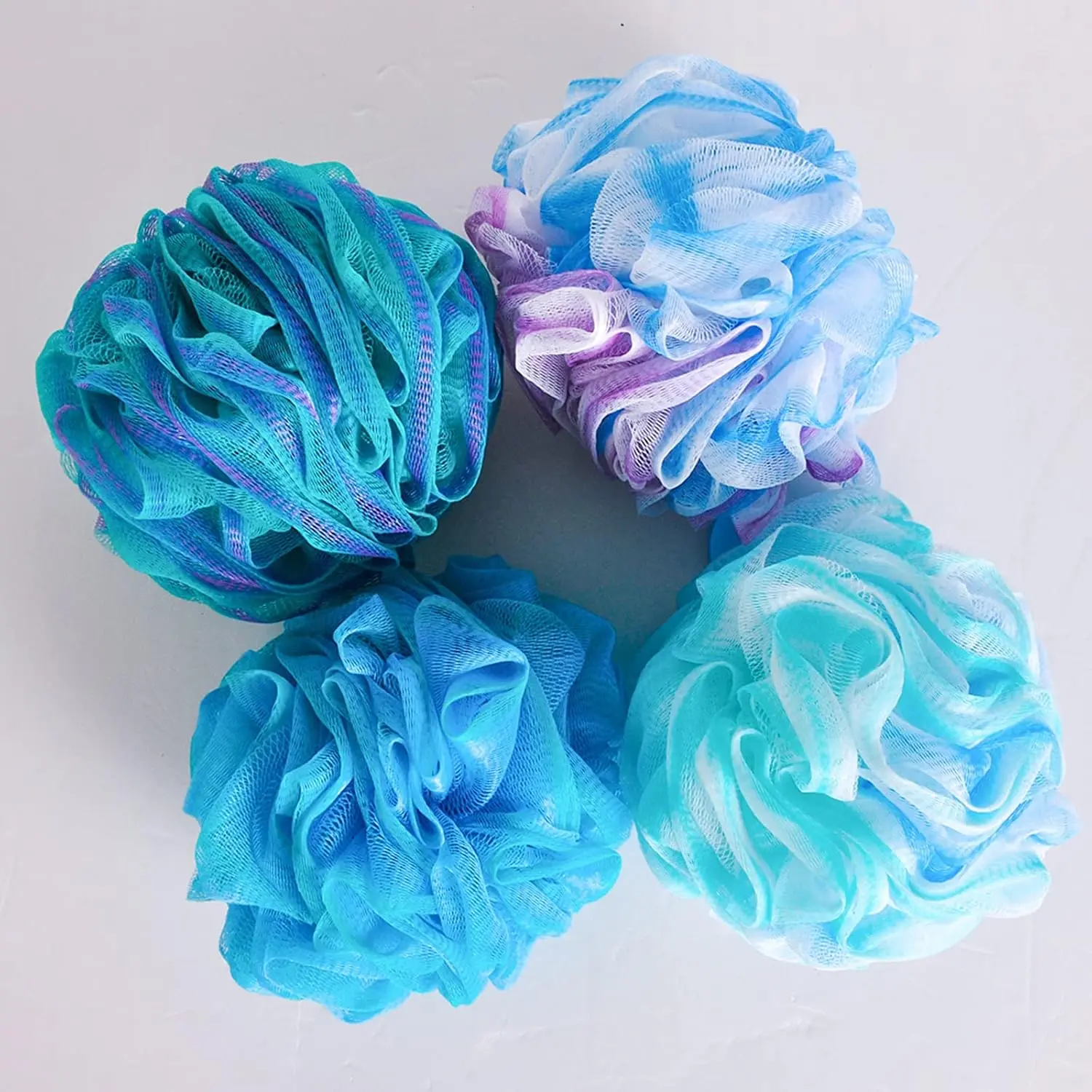 This set includes four colorful bath shower sponges designed with strong knotting for durability, creating a rich lather and gently exfoliating the skin.