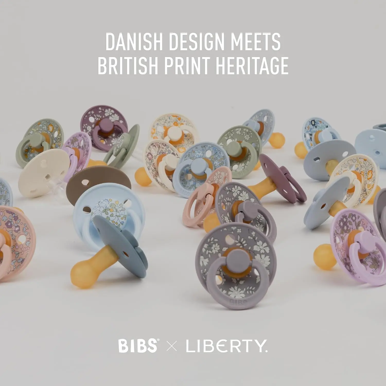 Bibs x Liberty 2-pack of size 2 latex pacifiers in a dusty blue Capel print, designed with a round nipple to mimic breastfeeding.