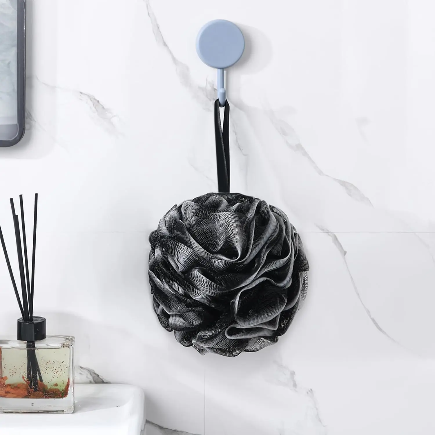 A black exfoliating loofah sponge for use as a body scrubber in the bath or shower.