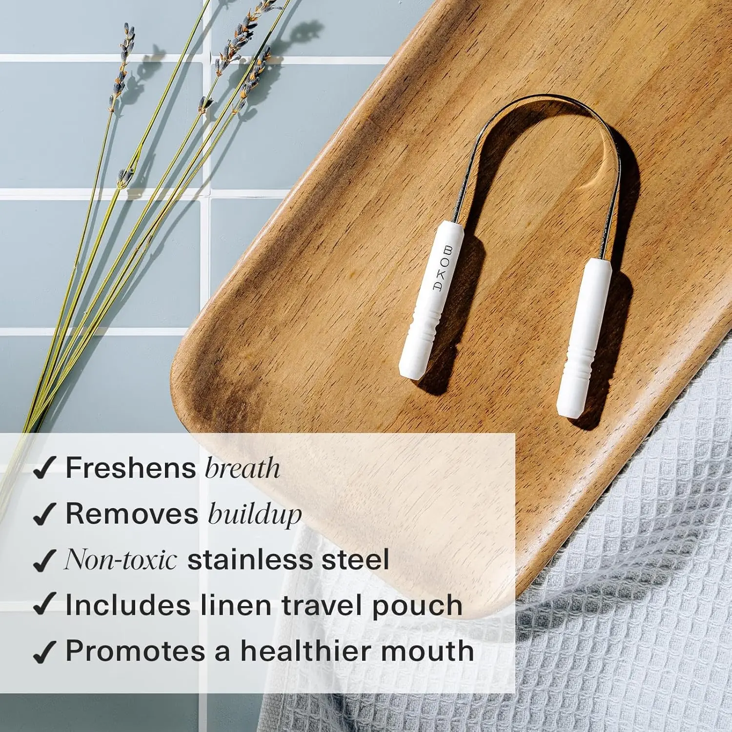 This stainless steel Boka tongue scraper effectively removes buildup, promoting fresh breath and healthier taste buds with its ergonomic design, and comes with a linen travel pouch.