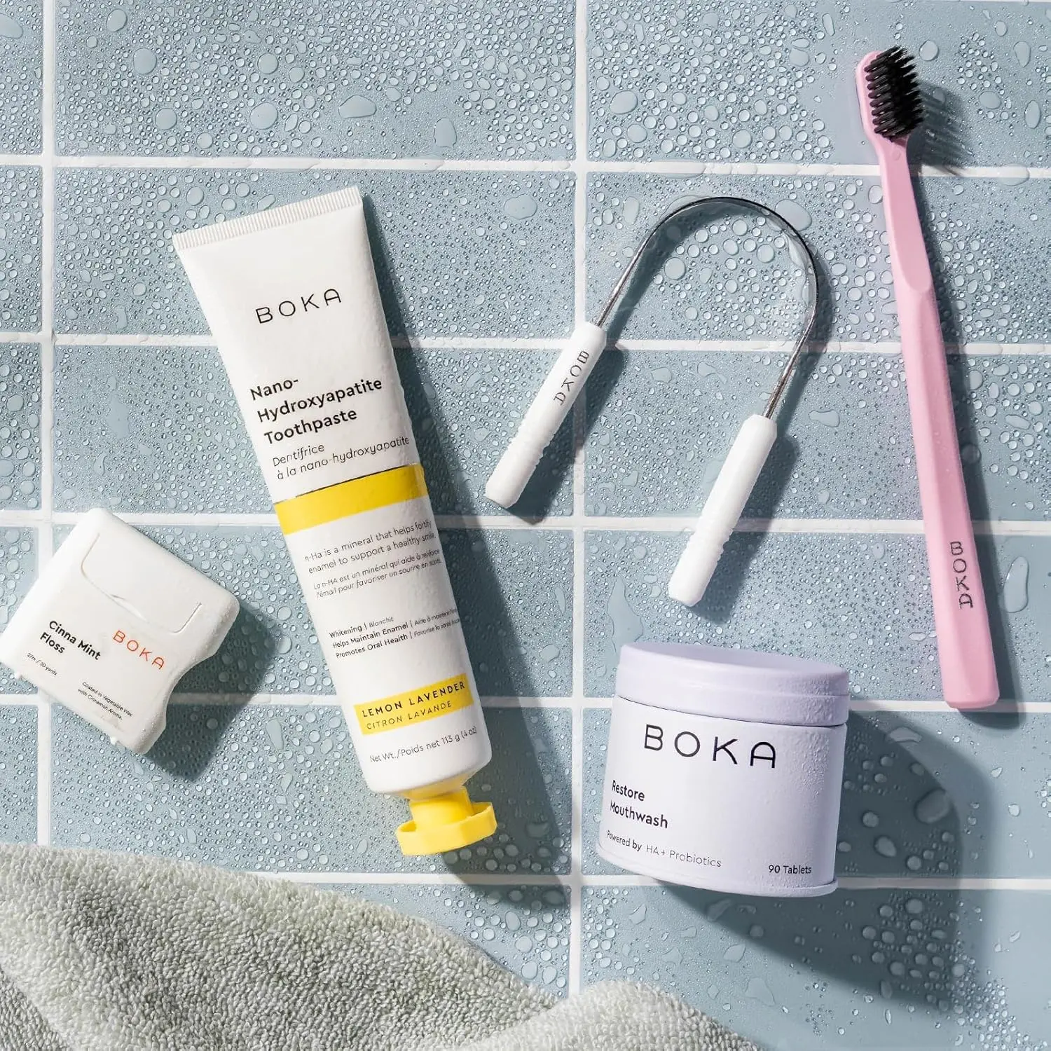 This stainless steel Boka tongue scraper effectively removes buildup, promoting fresh breath and healthier taste buds with its ergonomic design, and comes with a linen travel pouch.