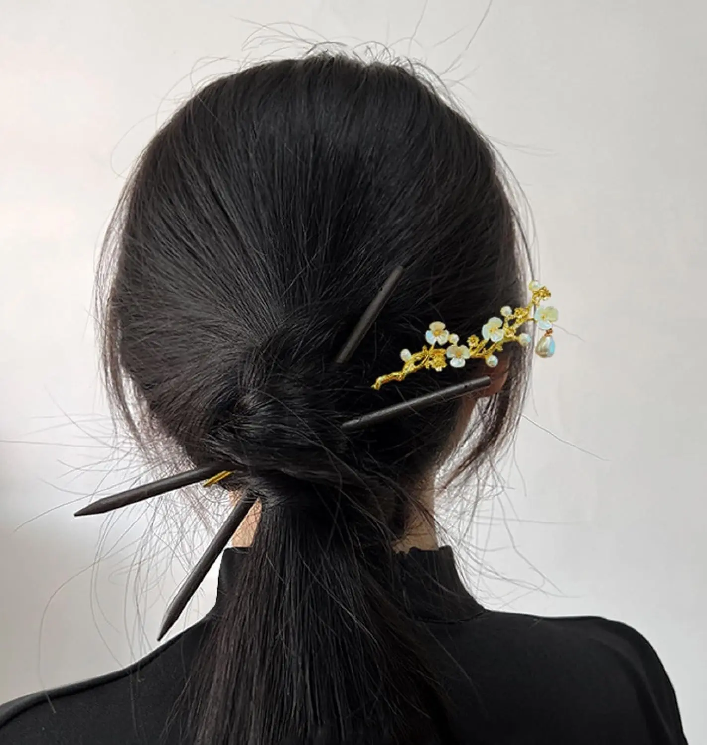 Four elegant floral Chinese hair sticks offer a vintage and stylish way to accessorize long hair.