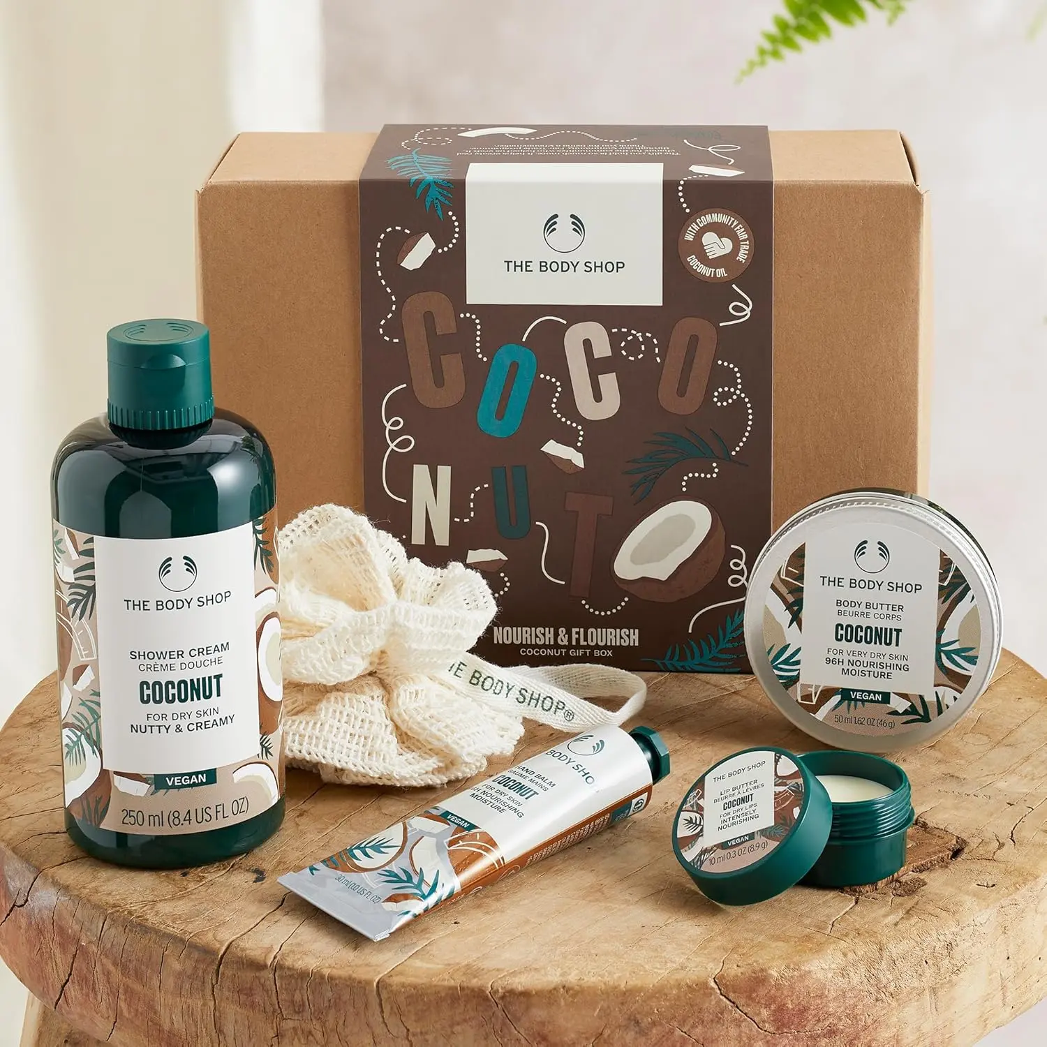 The Body Shop Coconut Nourish & Flourish gift set includes coconut shower cream, body butter, hand balm, lip butter, and a mini ramie bath lily for a complete pampering experience.