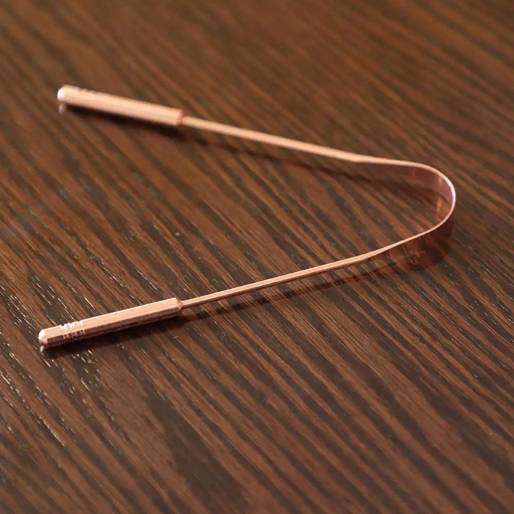 This high-quality copper tongue cleaner with stainless steel comfort grip handles gently removes bacteria and plaque for improved oral hygiene and fresh breath.