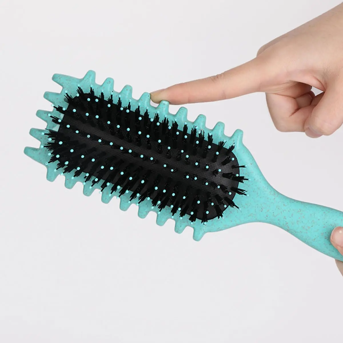 This pink curl defining brush is designed with an ergonomic handle and open vent for effortless styling, detangling, and shaping of all curl types.