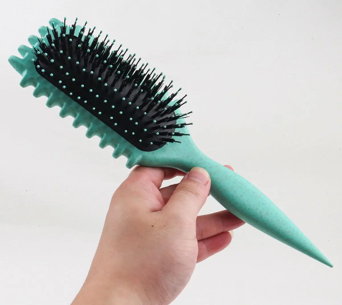 This pink curl defining brush is designed with an ergonomic handle and open vent for effortless styling, detangling, and shaping of all curl types.