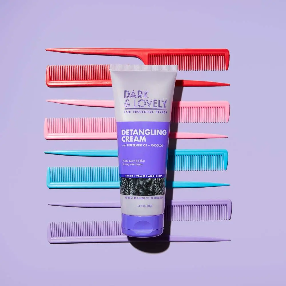 Bottle of Dark and Lovely Detangling Cream with avocado and peppermint oil, designed for softening and conditioning hair during take down of braids, weaves, wigs, and locs.