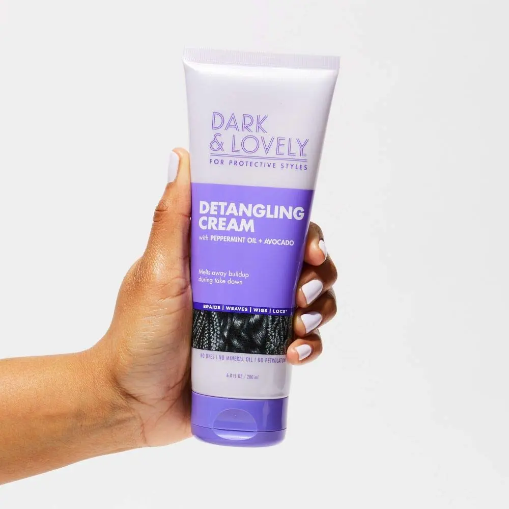 Bottle of Dark and Lovely Detangling Cream with avocado and peppermint oil, designed for softening and conditioning hair during take down of braids, weaves, wigs, and locs.