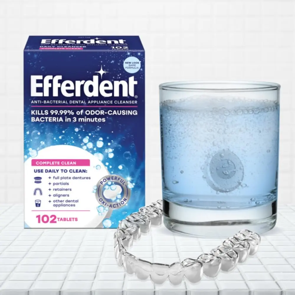 Efferdent Complete Clean antibacterial tablets are shown, designed for daily cleaning of retainers, dentures, aligners, and other dental appliances, effectively removing stains and fighting odor-causing bacteria.