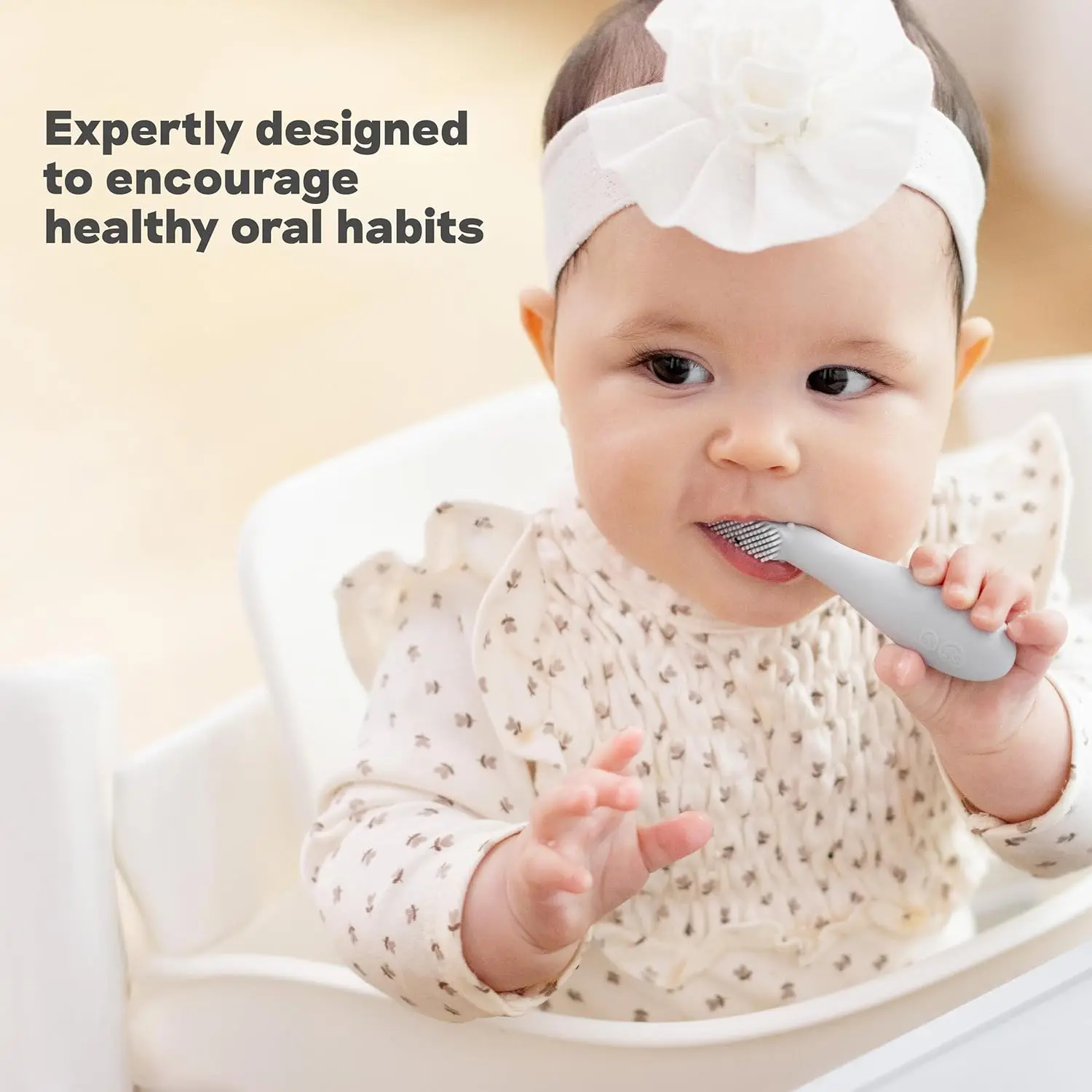 Sage-colored silicone baby toothbrush designed for infants 3+ months with an easy-grip handle and sensory bumps for early oral care.