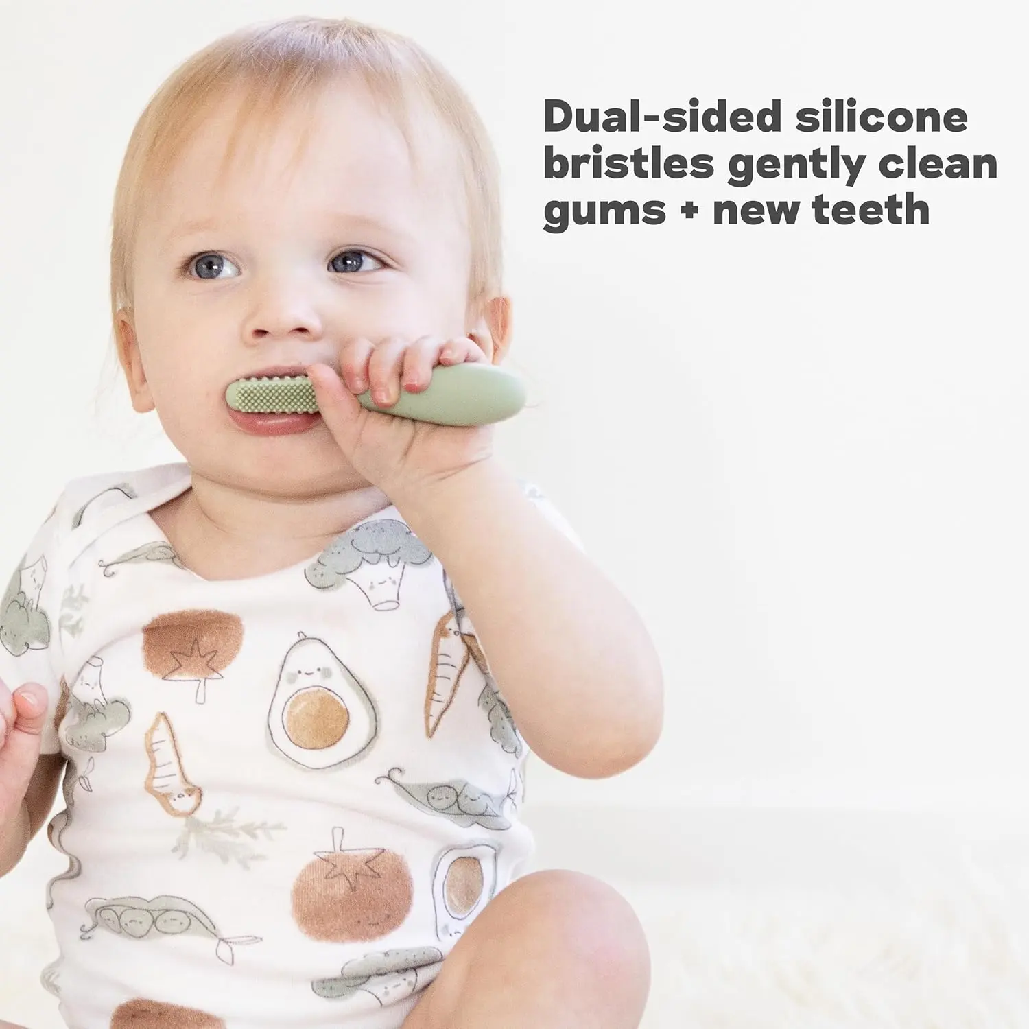 Sage-colored silicone baby toothbrush designed for infants 3+ months with an easy-grip handle and sensory bumps for early oral care.