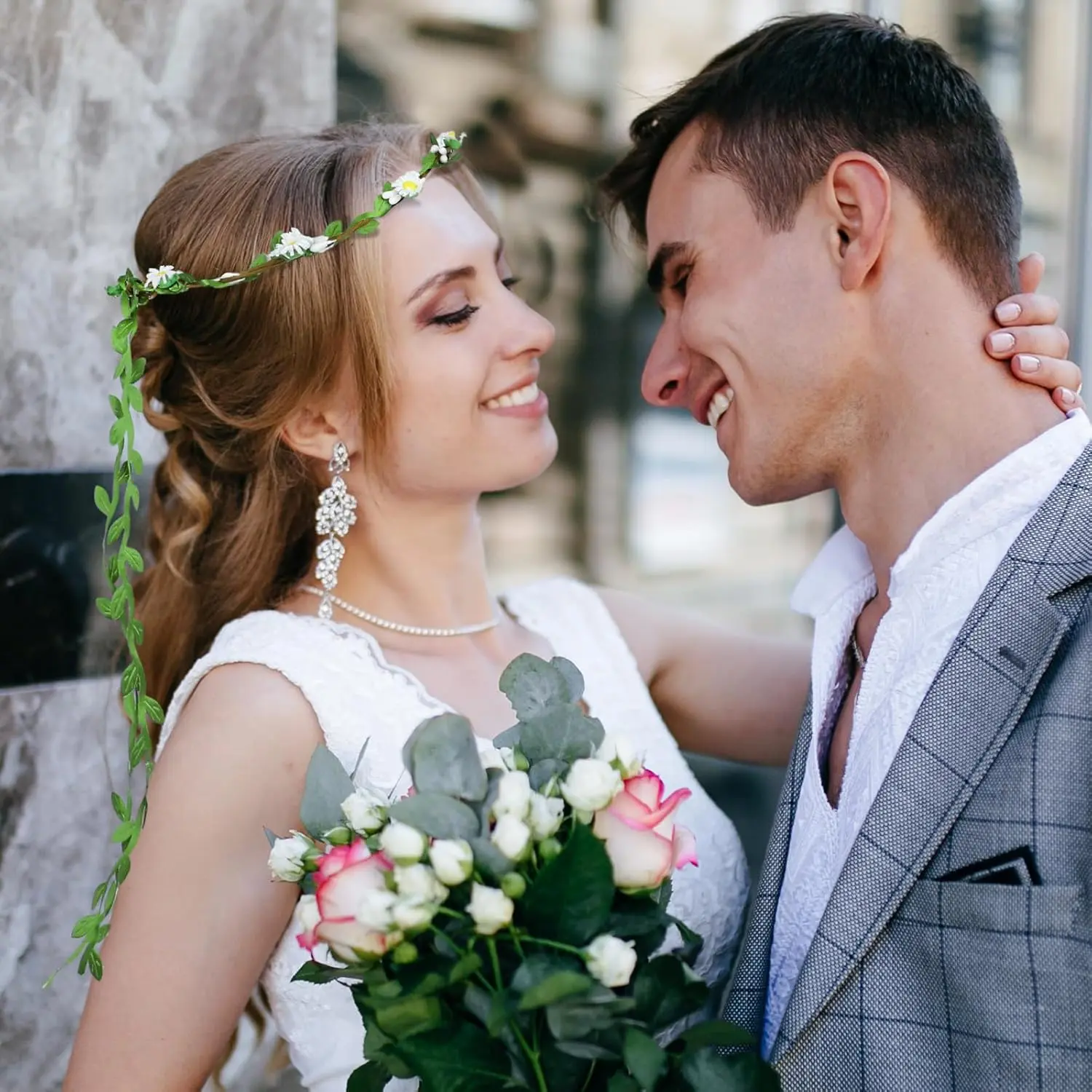 Two handmade flower crown headbands with artificial daisies, silk flowers, and green leaves, perfect for weddings and adding a bohemian touch to any hairstyle.