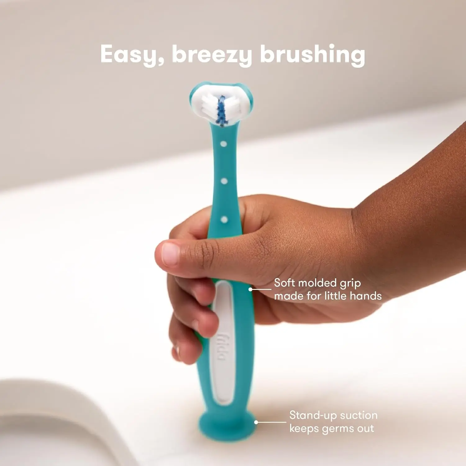 This blue Frida Baby Toothhugger toothbrush features a u-shaped head with triple-angle bristles for toddlers learning to brush.
