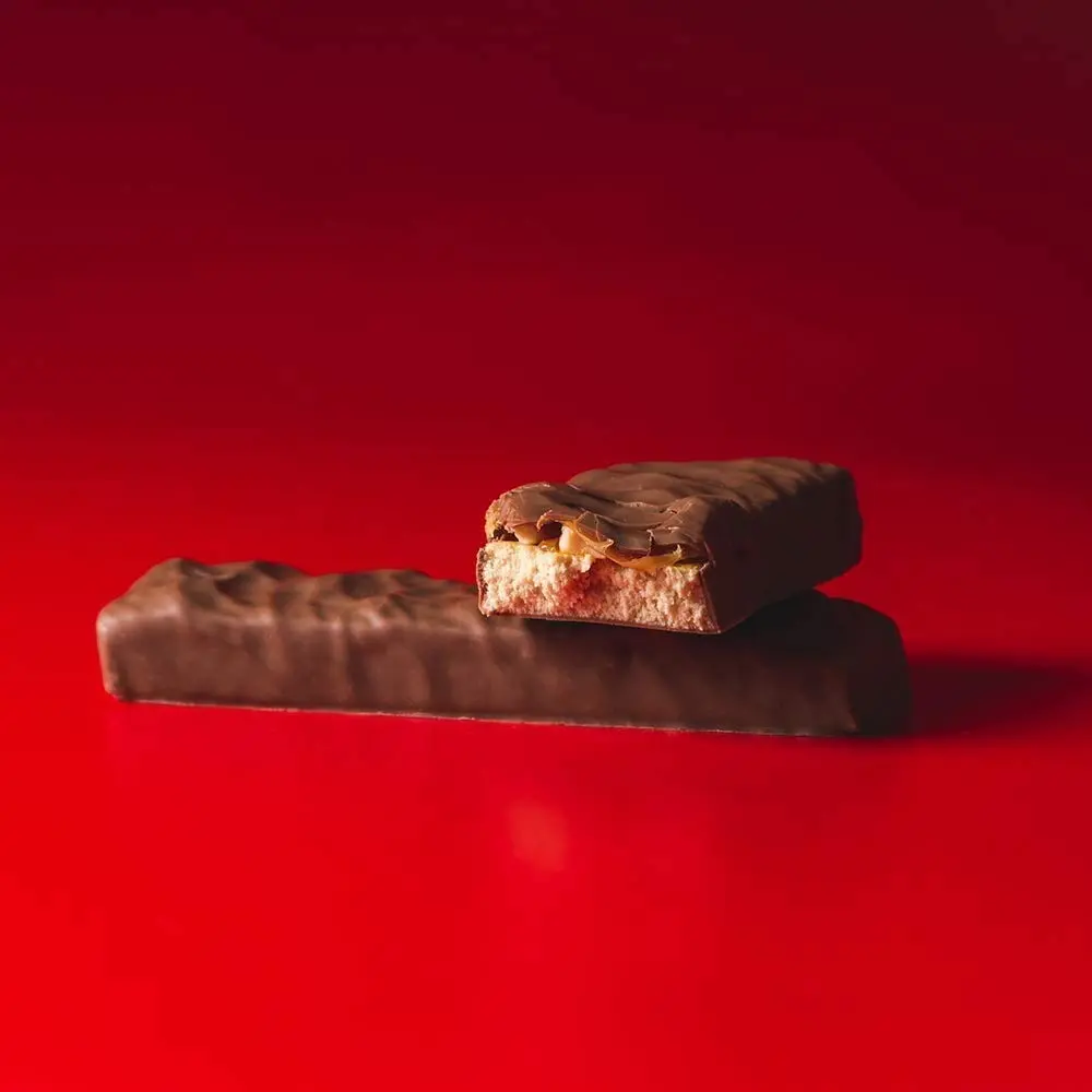 Twelve 60-gram Grenade Carb Killa Peanut Nutter protein bars, a unisex food supplement for active lifestyles.