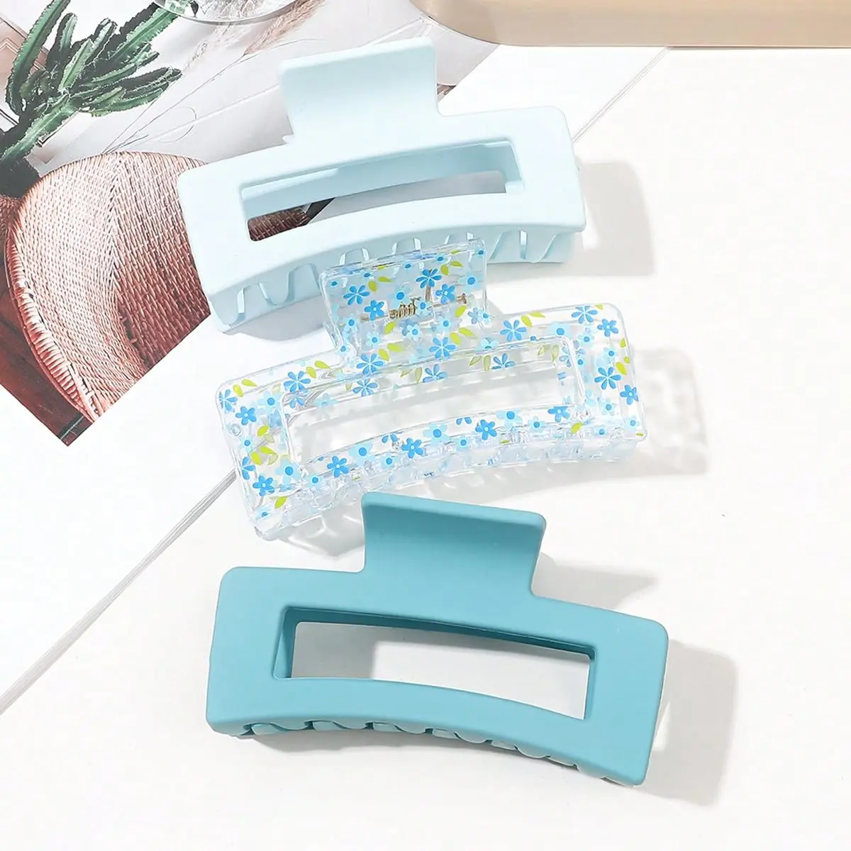 Three square hair claw clips in different colors securely holding thick hair for women.