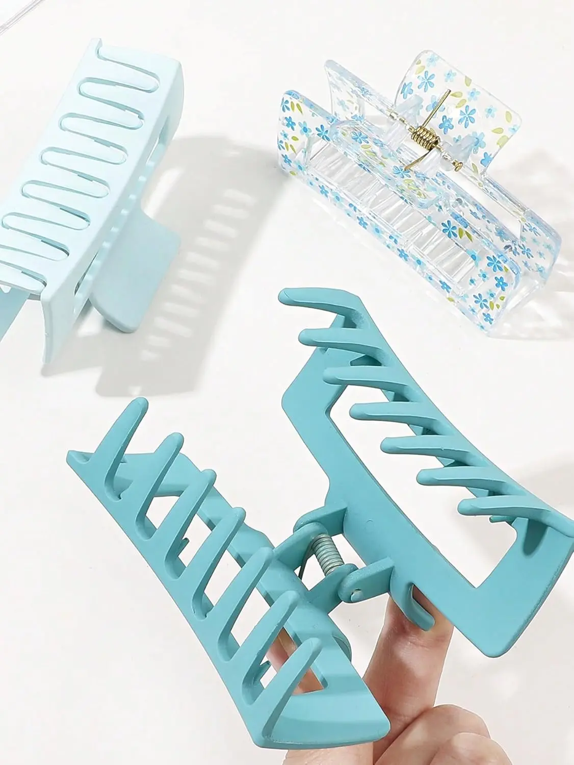 Three square hair claw clips in different colors securely holding thick hair for women.