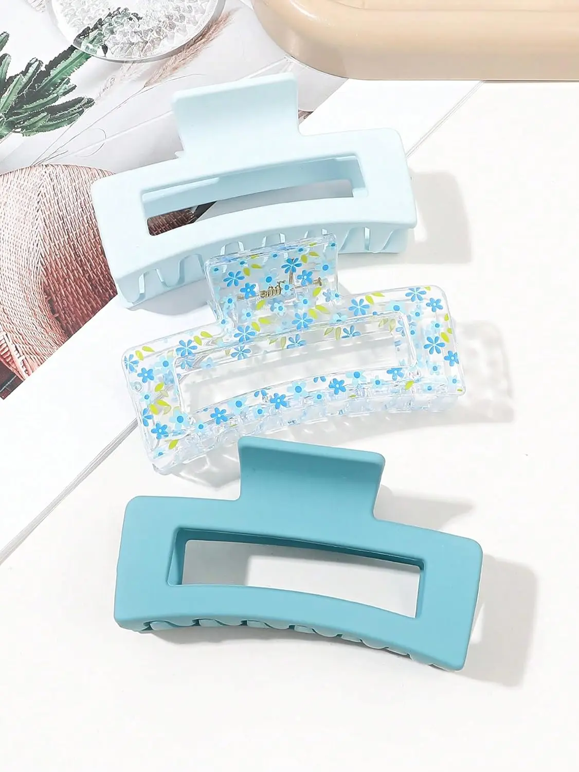 Three square hair claw clips in different colors securely holding thick hair for women.