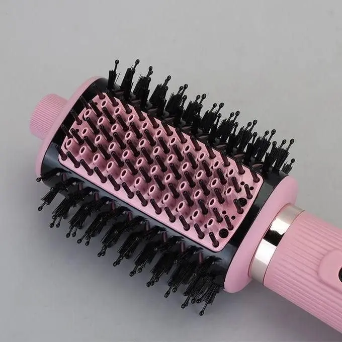 Pink 4-in-1 hair dryer brush with ionic technology for drying, straightening, volumizing and styling hair, featuring a lightweight and ergonomic design.