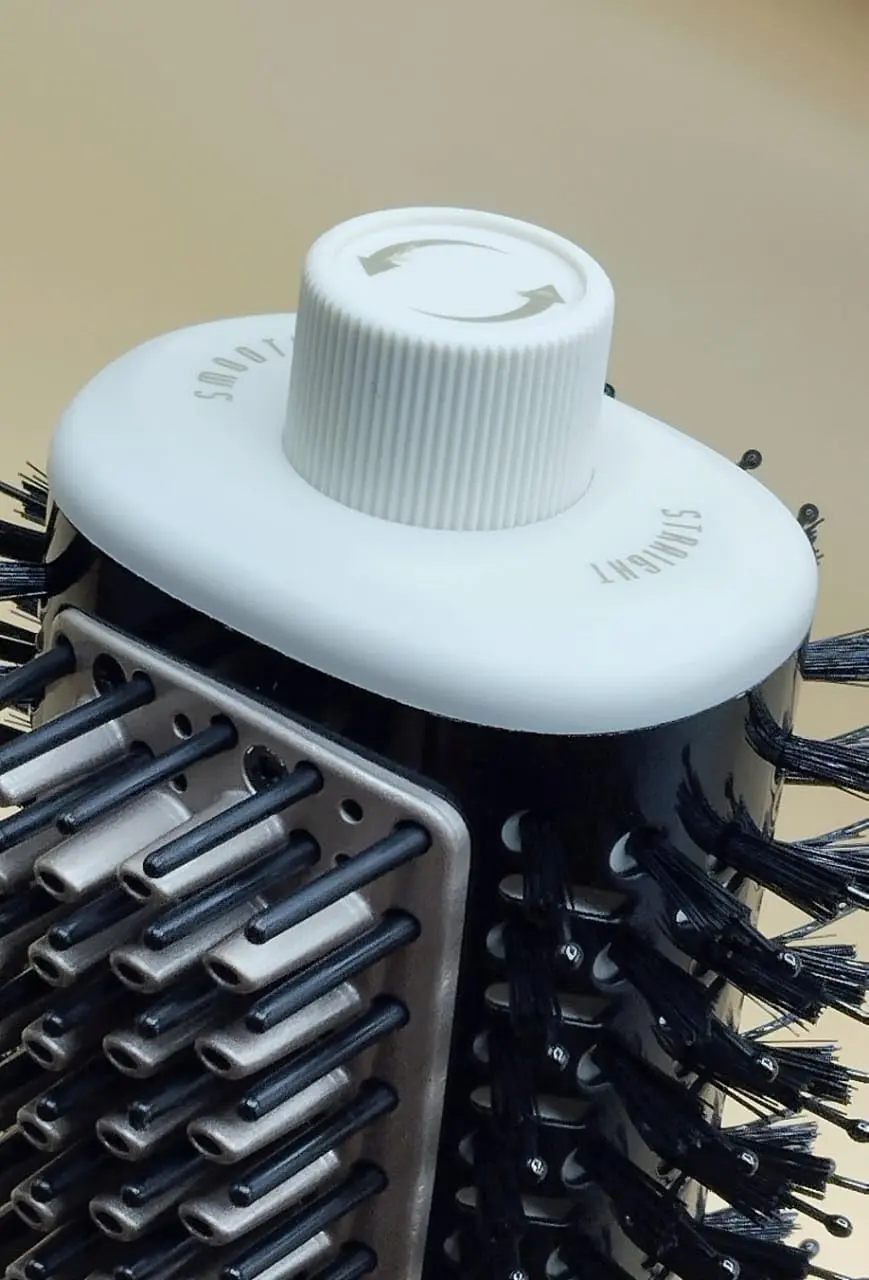 Pink 4-in-1 hair dryer brush with ionic technology for drying, straightening, volumizing and styling hair, featuring a lightweight and ergonomic design.