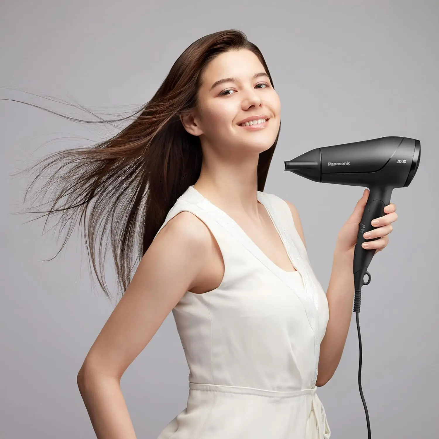 Black Panasonic hair dryer with heat protection mode, a styling nozzle, and a foldable handle for easy storage and travel.
