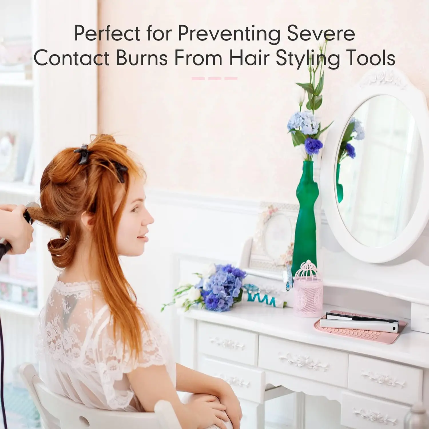 Pink silicone heat resistant mat safely holds hot curling iron and hair straightener, protecting surfaces from heat damage with its non-slip wave design and convenient hanging strap.