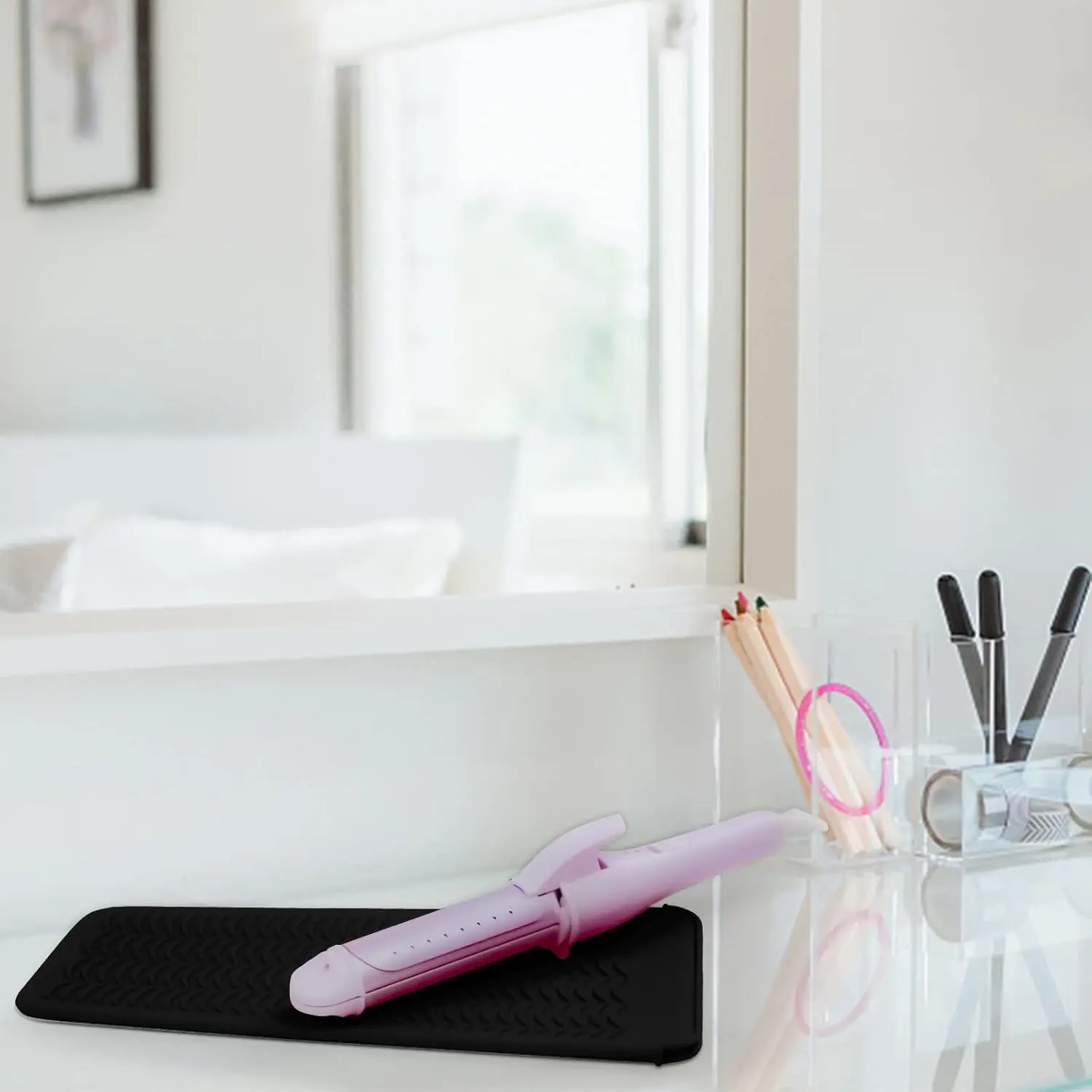 Two black silicone heat resistant mat pouches are displayed, designed for storing hot hair styling tools like flat irons and curling irons, protecting surfaces from heat damage.