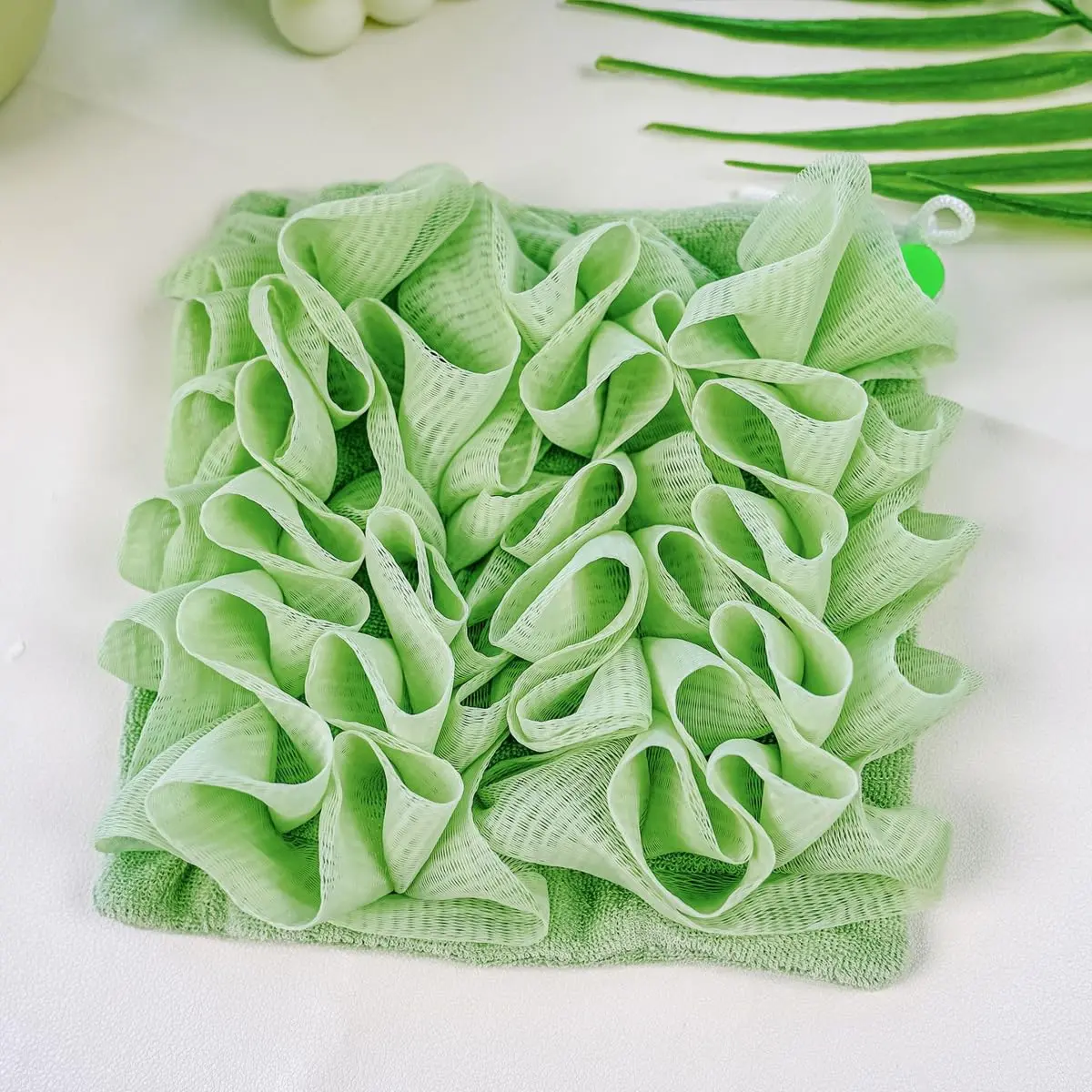 A green loofah washcloth and mesh shower ball are designed for exfoliating and cleansing with bar soap or body wash for smooth skin.