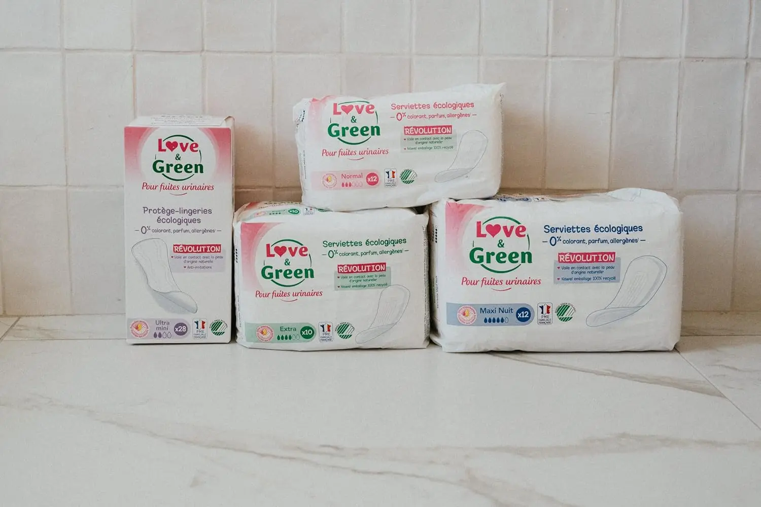 Twenty-eight Love & Green hypoallergenic incontinence pads made with 100% natural origin materials, free of chlorine, perfume, dyes, lotion, allergens, petrolatum, and paraffin, and dermatologically tested for sensitive skin.