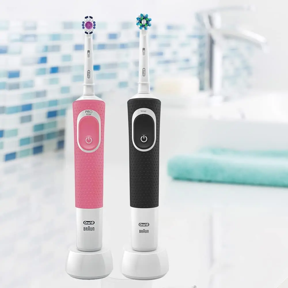 The Oral-B Vitality D100 electric toothbrush bundle features a black handle with a Cross Action brush head and a pink handle with a 3D White brush head, offering an ergonomic design, quadrant timer and rechargeable battery for better oral hygiene.