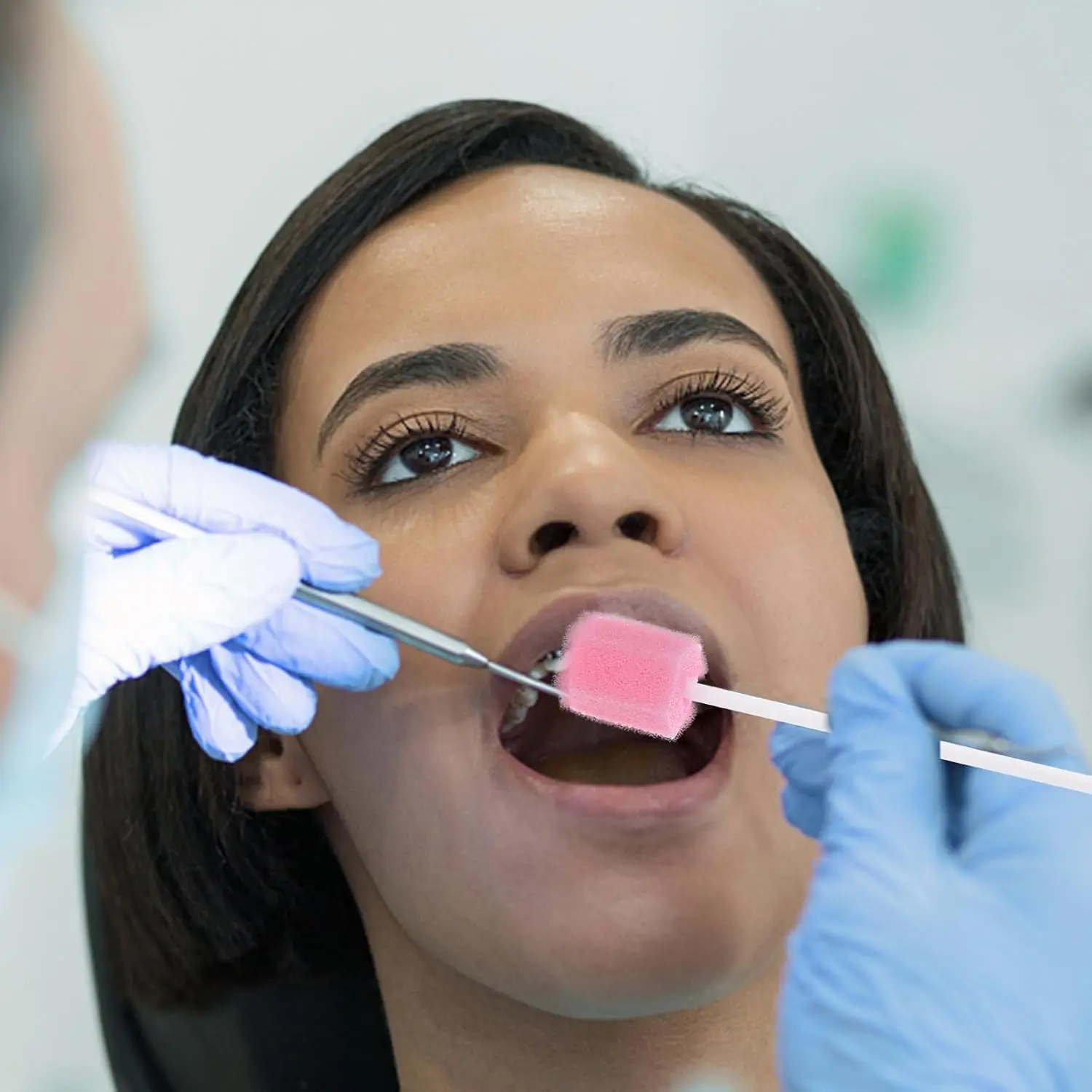 Pink disposable oral care sponge swabs gently clean and moisten sensitive teeth and gums for seniors, adults, and children.