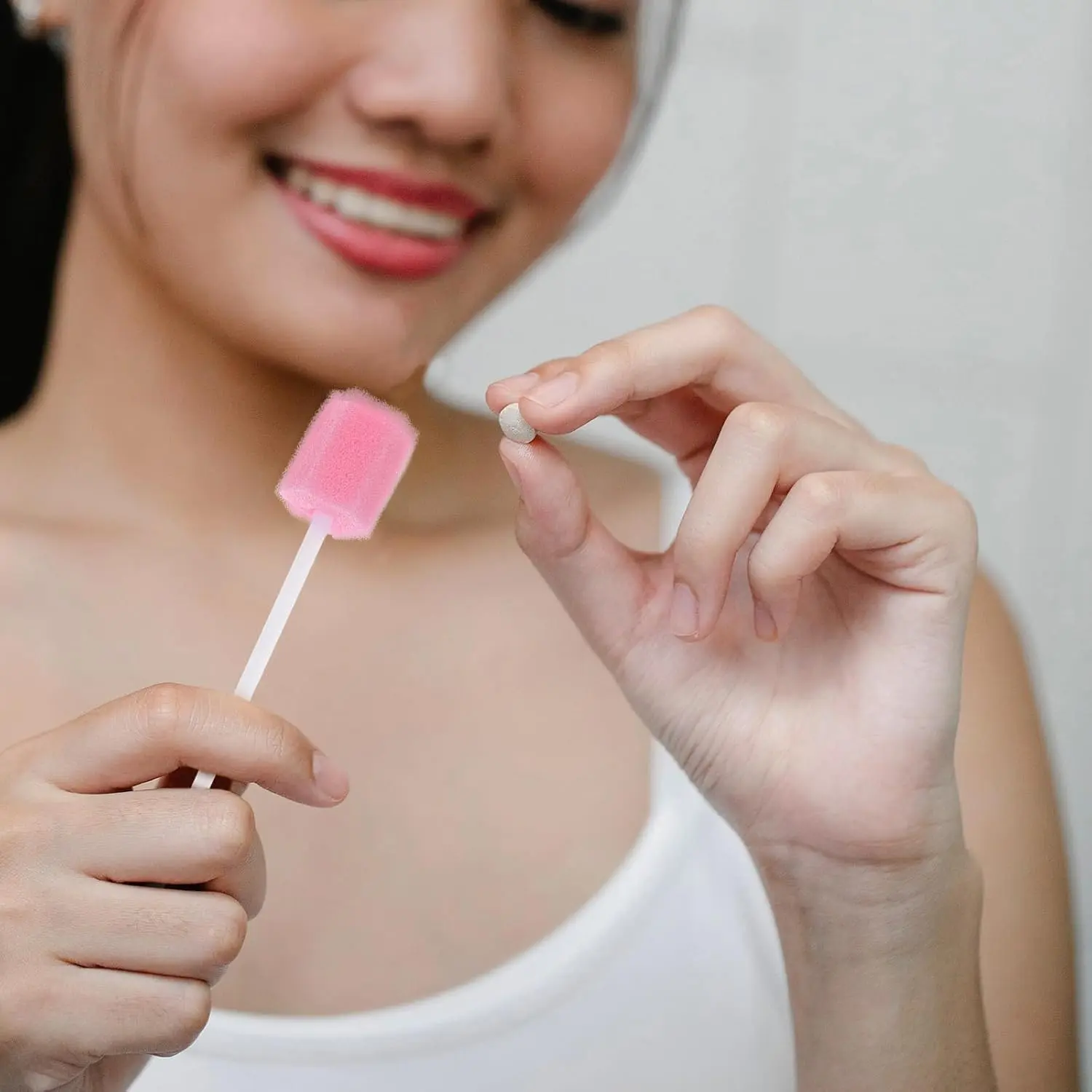 Pink disposable oral care sponge swabs gently clean and moisten sensitive teeth and gums for seniors, adults, and children.