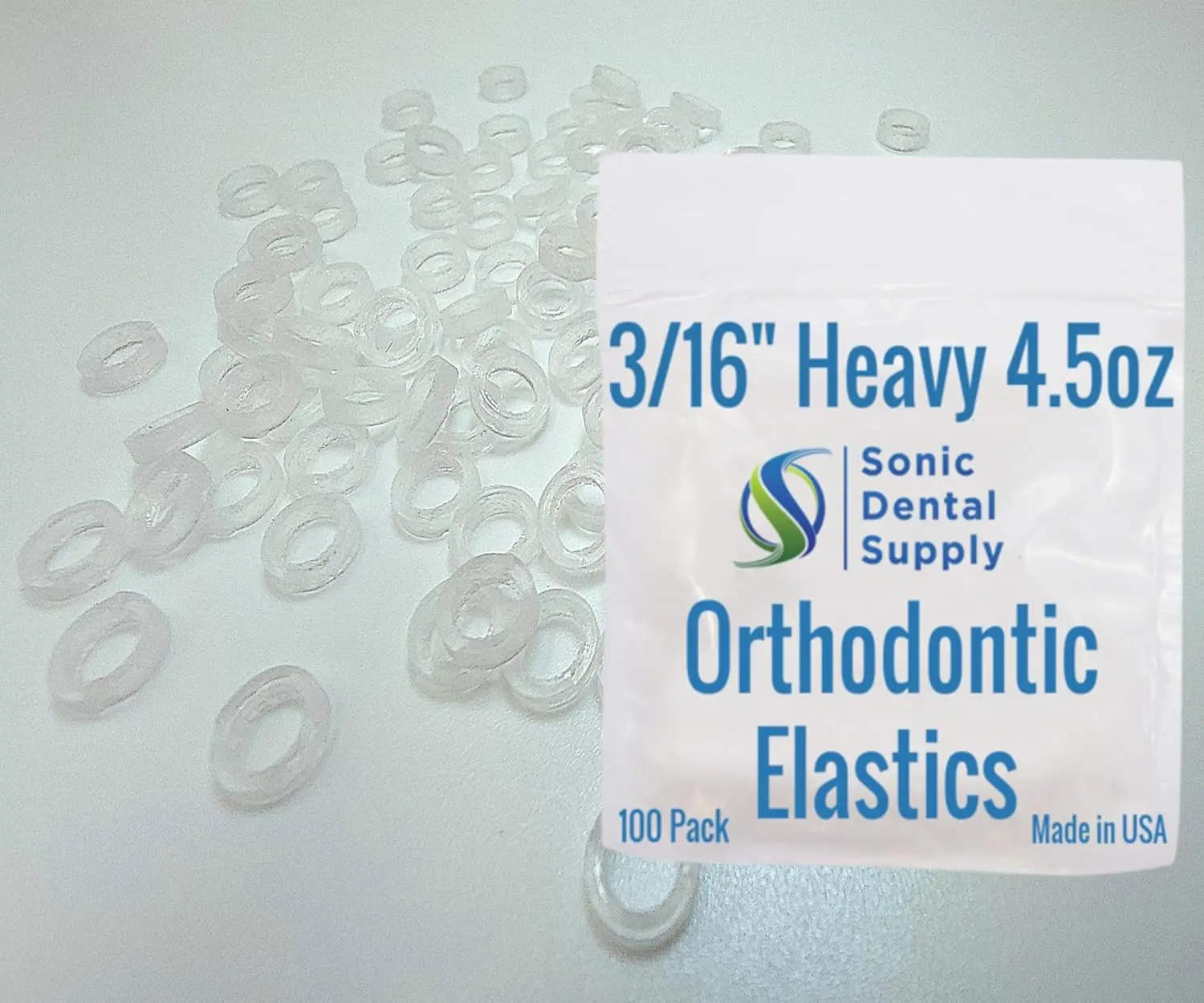 A close-up shows a small pile of clear, latex-free orthodontic elastic rubber bands, size 3/16 inch with light force, designed for braces and other uses.