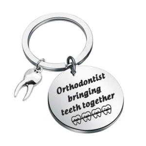 Stainless steel orthodontist keychain with "Orthodontist Bringing Teeth Together" engraving, a perfect gift for dental professionals, presented in a velvet gift bag.