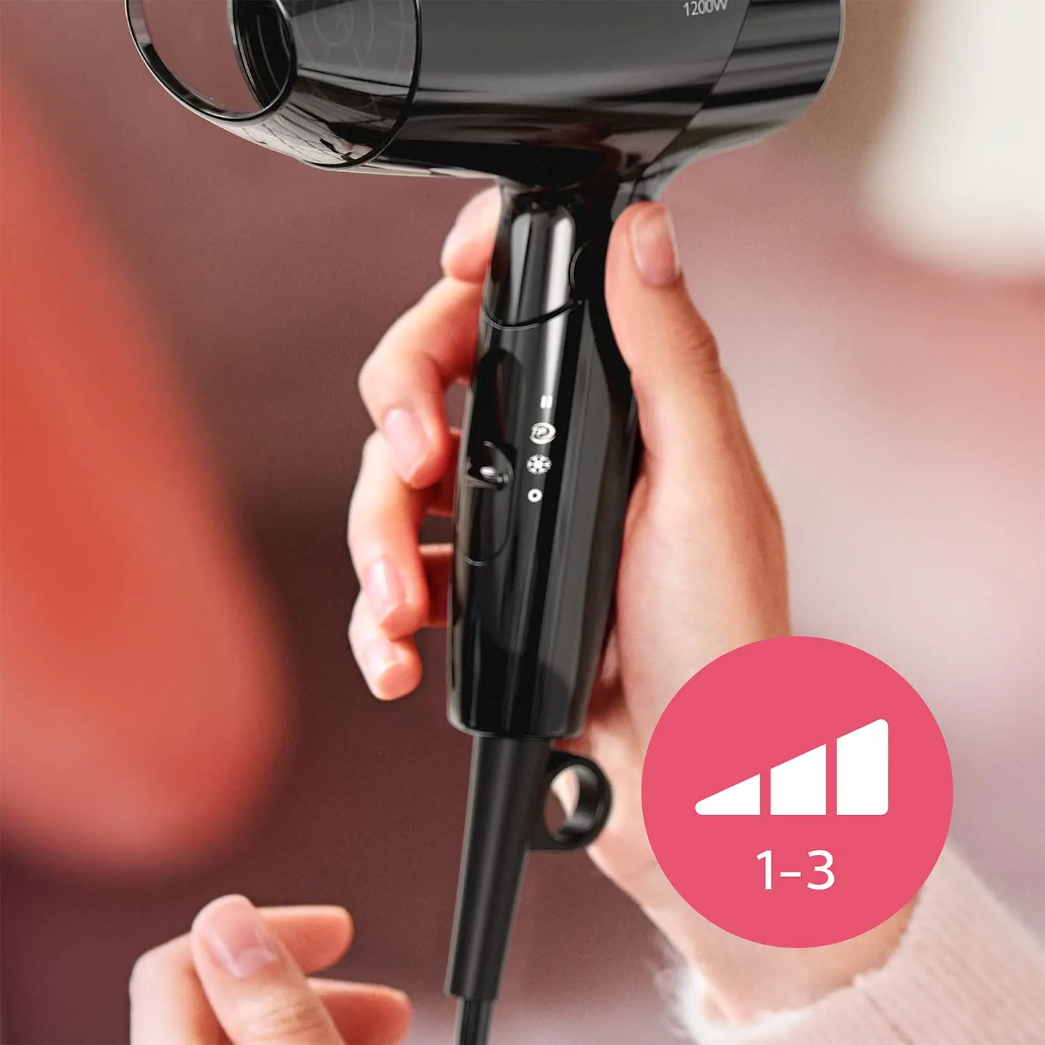 Black Philips Essential Care BHC010/10 hair dryer with ThermoProtect setting and foldable handle, offering 1200W power for quick, gentle, and shiny hair drying with three preset levels and a styling nozzle.