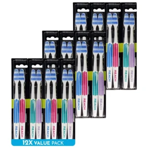 A 24-pack of REACH toothbrushes with firm, bi-level bristles and an angled neck design, shown in assorted colors like pink, green, blue, and purple, for effectively cleaning between teeth and hard-to-reach areas.