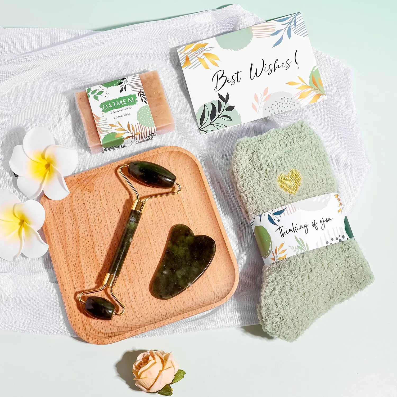 This self care gift basket for women includes a blanket, tumbler, candle, soap, bath bomb, jade roller set, eye mask, and socks.
