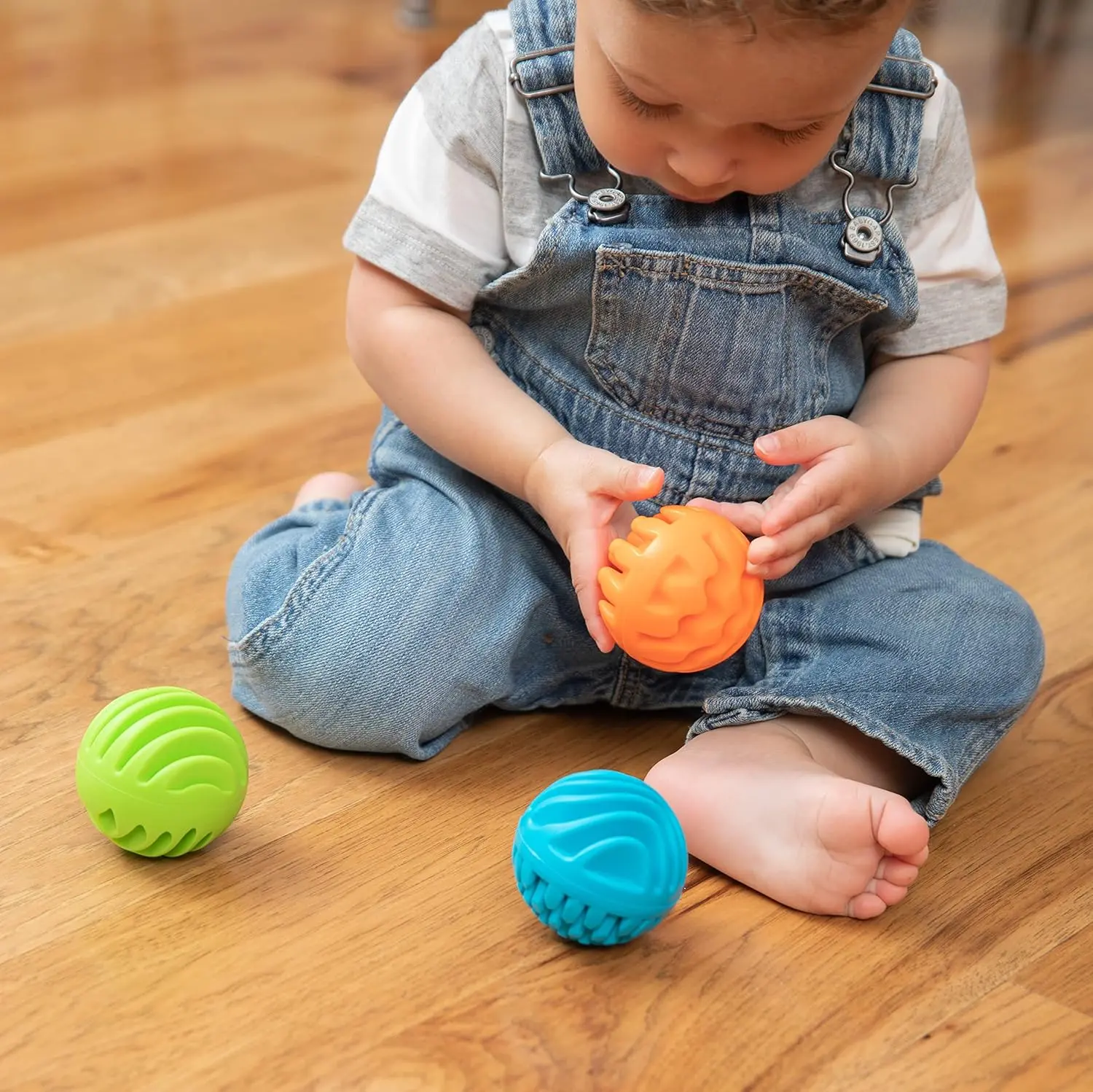 Three textured silicone sensory rollers with chimes inside, designed for infants 6 months and older to encourage sensory exploration and tactile learning.