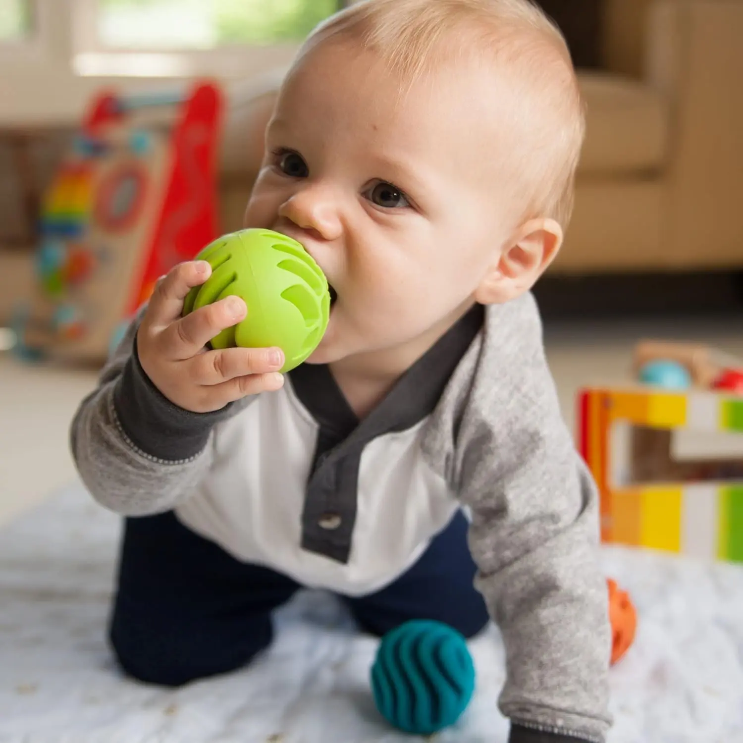 Three textured silicone sensory rollers with chimes inside, designed for infants 6 months and older to encourage sensory exploration and tactile learning.