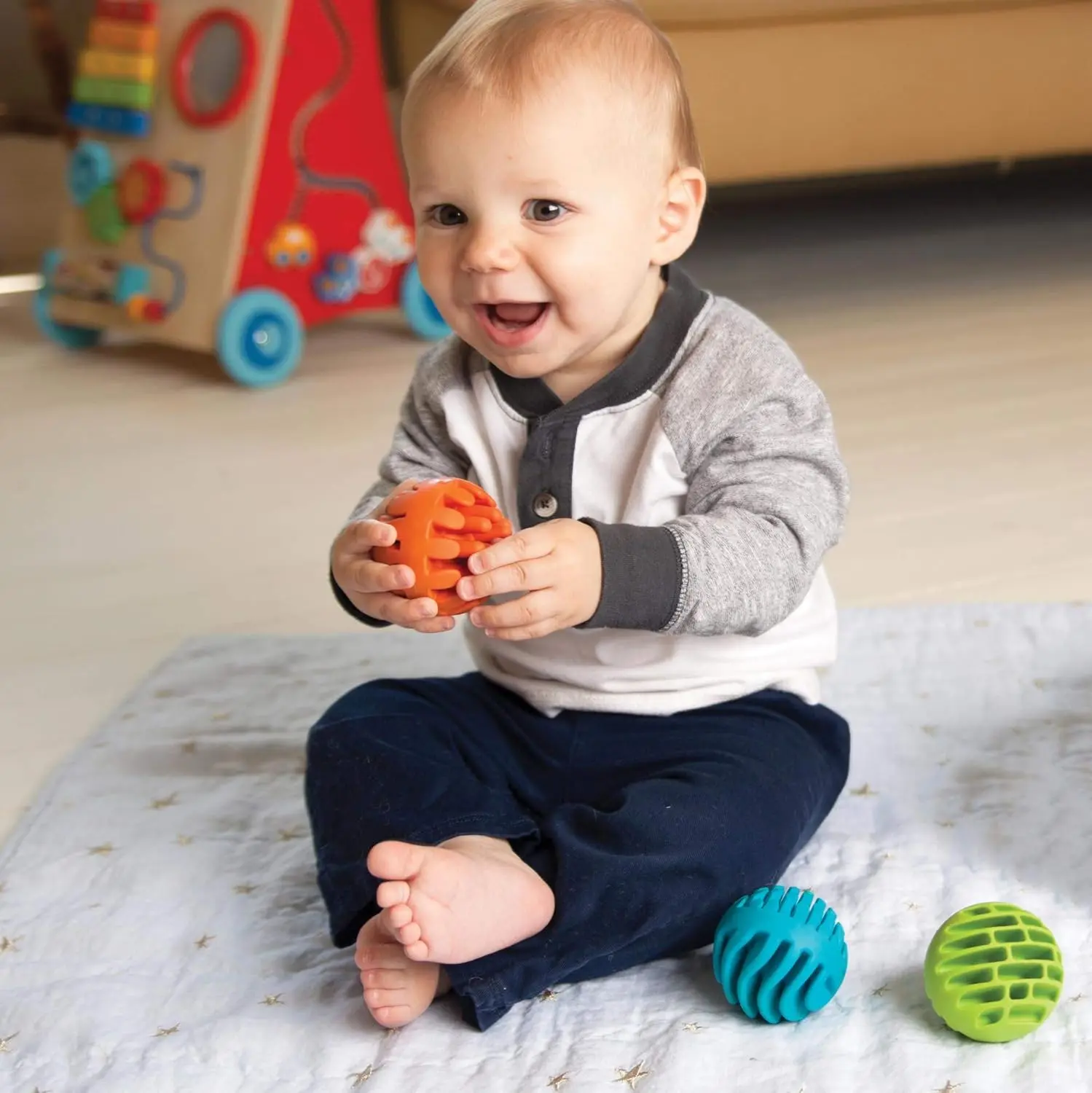 Three textured silicone sensory rollers with chimes inside, designed for infants 6 months and older to encourage sensory exploration and tactile learning.